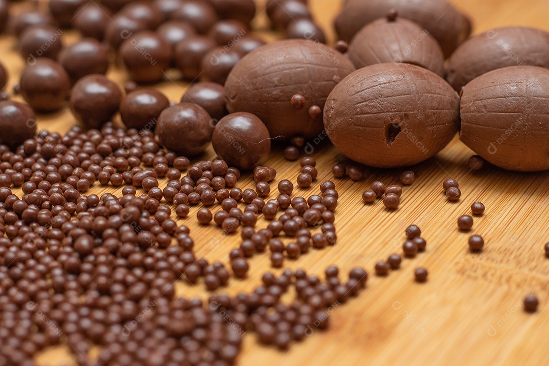 Diferentes tipos de bolas de chocolate em uma tigela cinza com uma colher cheia de chocolate