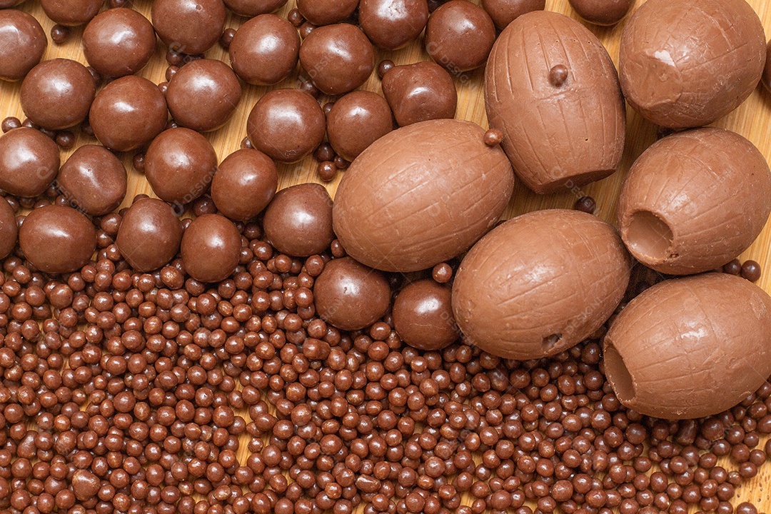 Diferentes tipos de bolas de chocolate em uma tigela cinza com uma colher cheia de chocolate