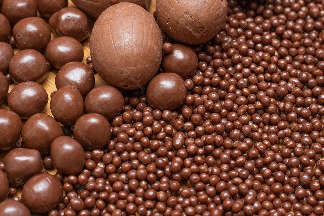 Different types of chocolate balls in a gray bowl with a spoon full of chocolate