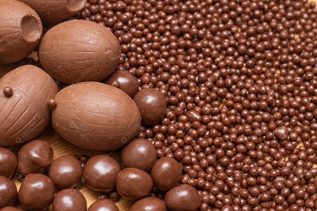 Diferentes tipos de bolas de chocolate em uma tigela cinza com uma colher cheia de chocolate