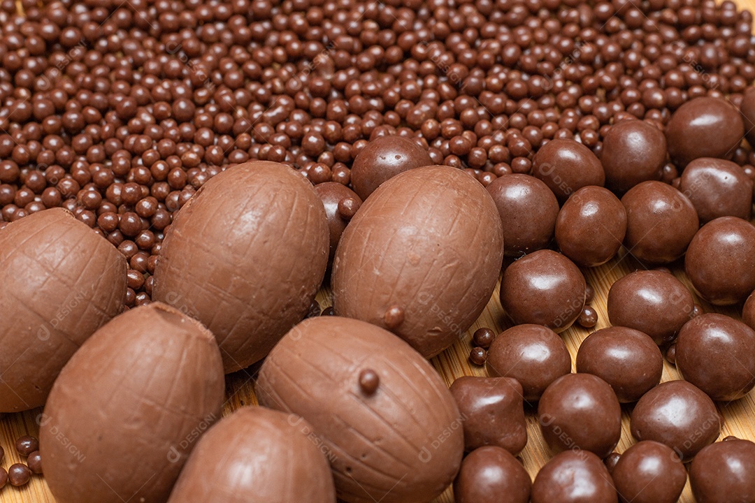 Diferentes tipos de bolas de chocolate em uma tigela cinza com uma colher cheia de chocolate