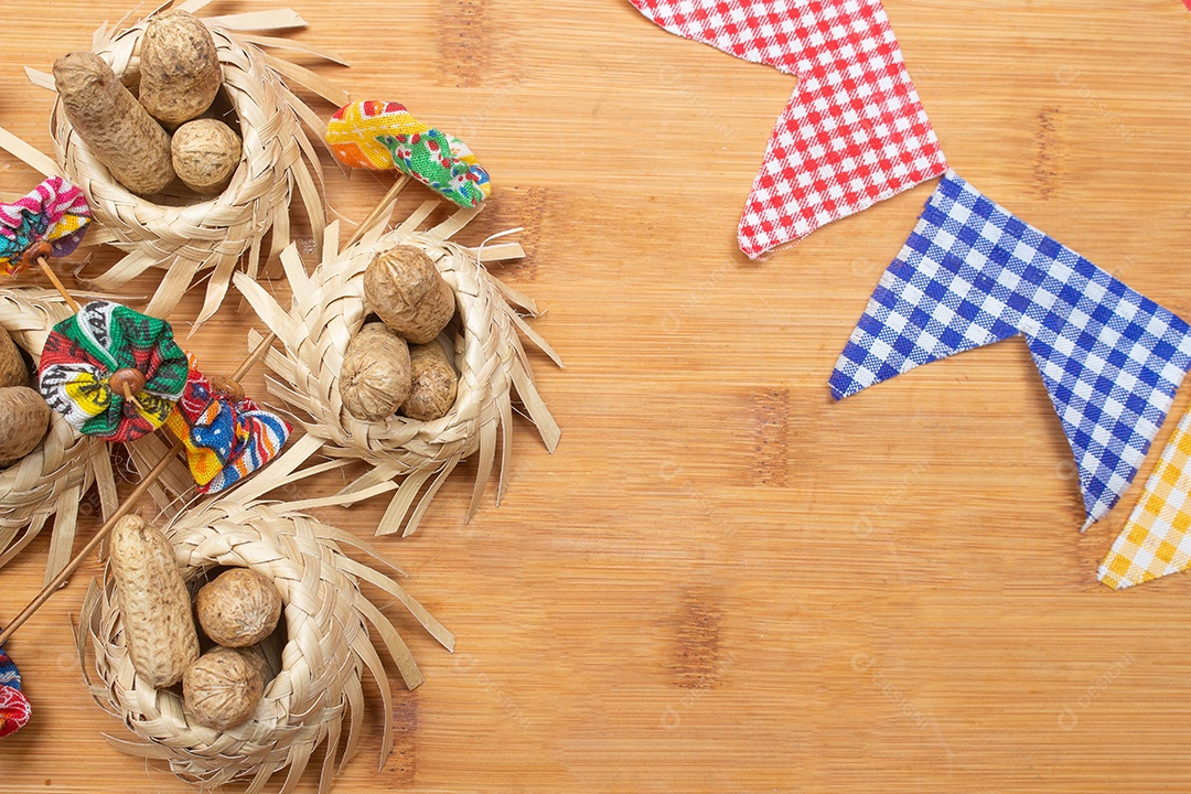 Pequenos chapéus de palha cheios de amendoins com decorações de festa junina brasileira