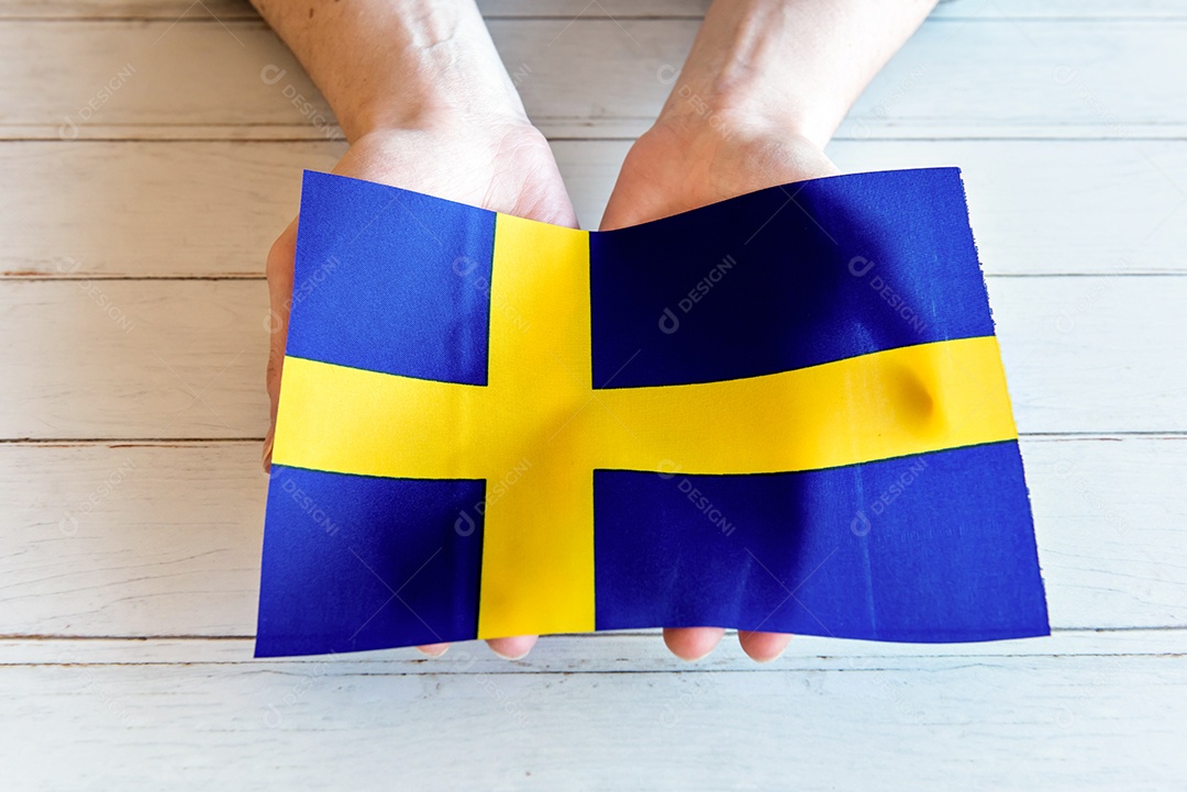 mãos segurando a bandeira sueca