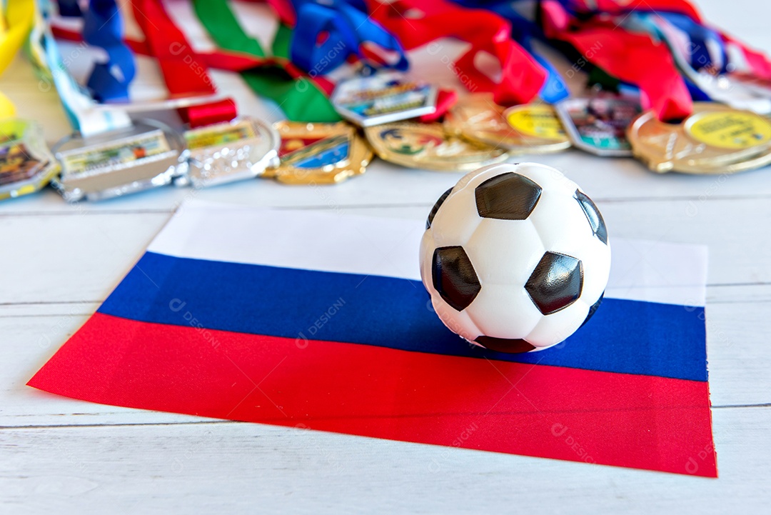 Bola de futebol e bandeira russa, medalhas borradas no fundo