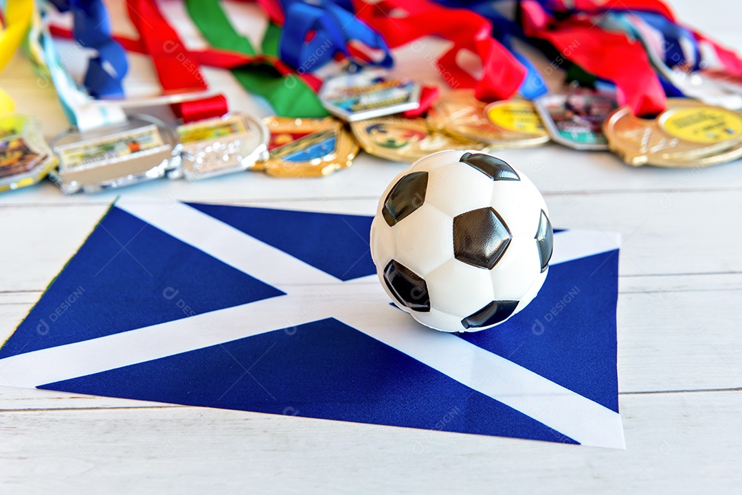 Bola de futebol e bandeira da Escócia, medalhas borradas no background