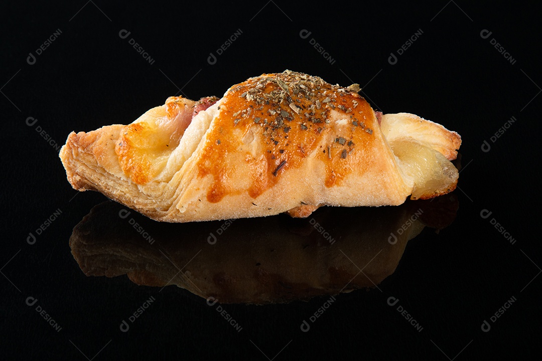 Croissant com queijo e presunto. Fundo preto.