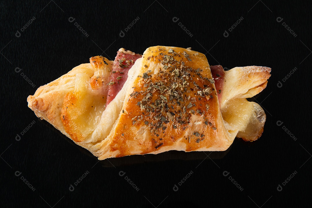 Croissant com queijo e presunto. Fundo preto.