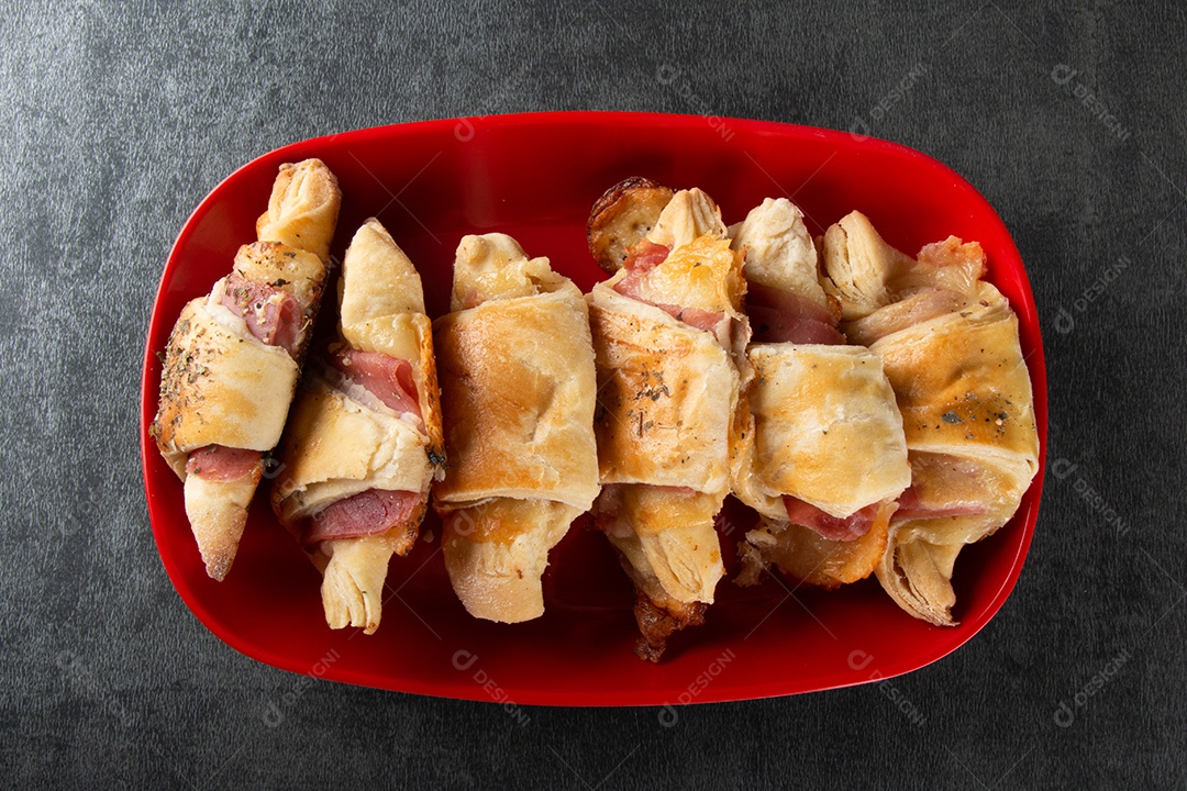 Croissant com queijo e presunto. Fundo cinza.