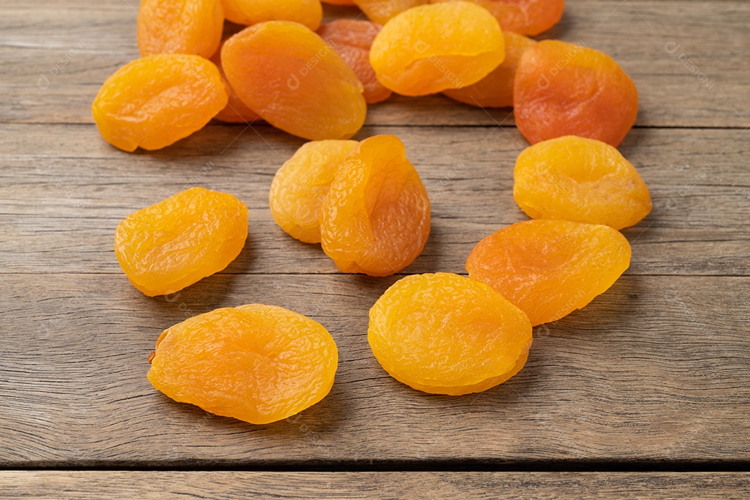 Grupo de damascos secos sobre a mesa de madeira.