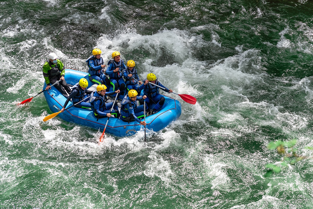 Grupos de jovens amigos se divertindo rafting nas corredeiras do rio