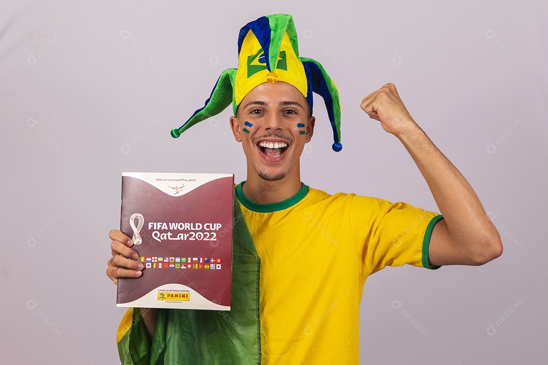 Homem jovem brasileiro torcedor segurando álbum da copa do mundo Futebol