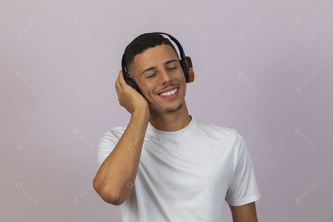 Homem jovem brasileiro sorridente usando fone de ouvido sobre fundo isolado branco