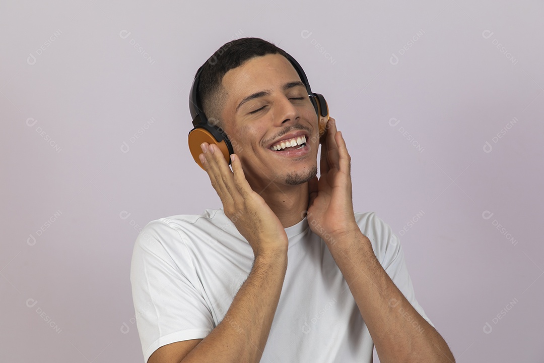 Homem jovem brasileiro usando fones de ouvido sobre fundo isolado branco