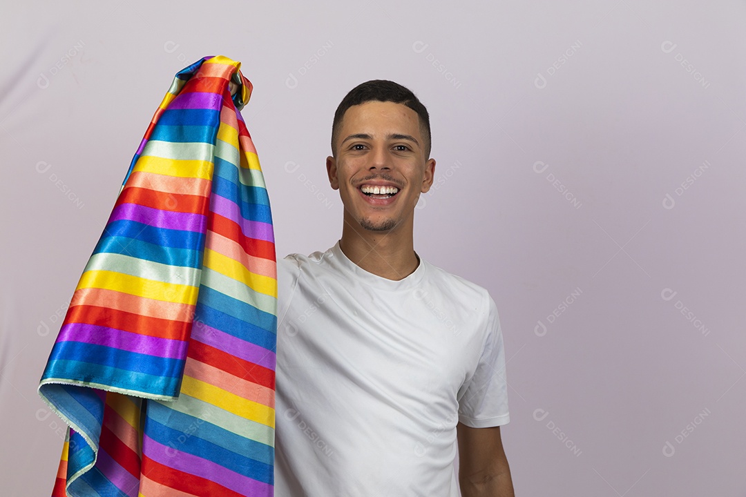 Homem jovem brasileiro segurando bandeira LGBTQI+ Orgulho Gay