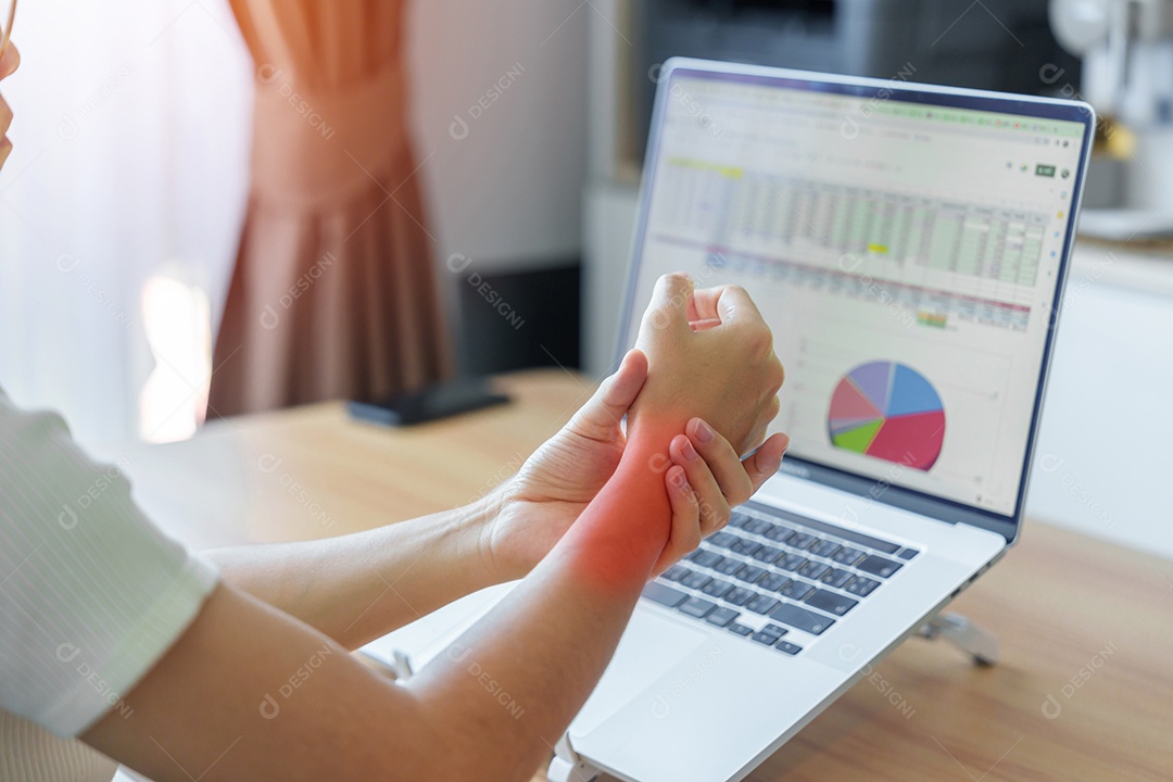 Mulher com dor no pulso ao usar laptop e mouse durante