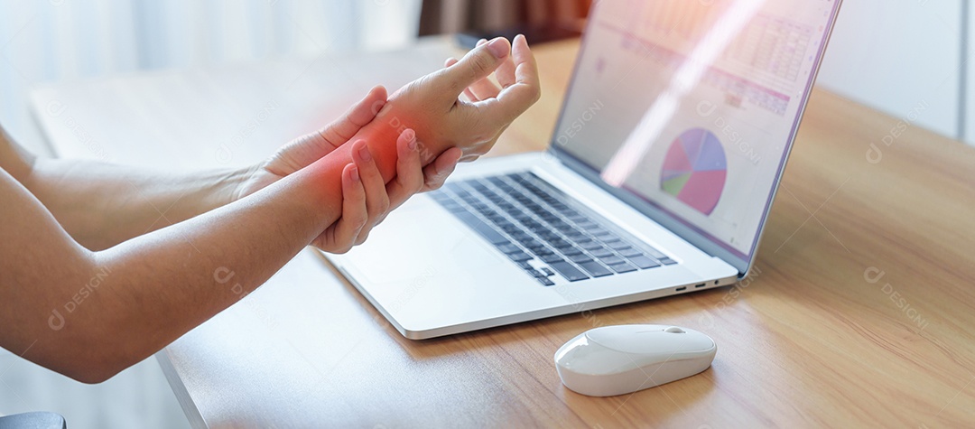 Mulher com dor no pulso ao usar laptop e mouse durante