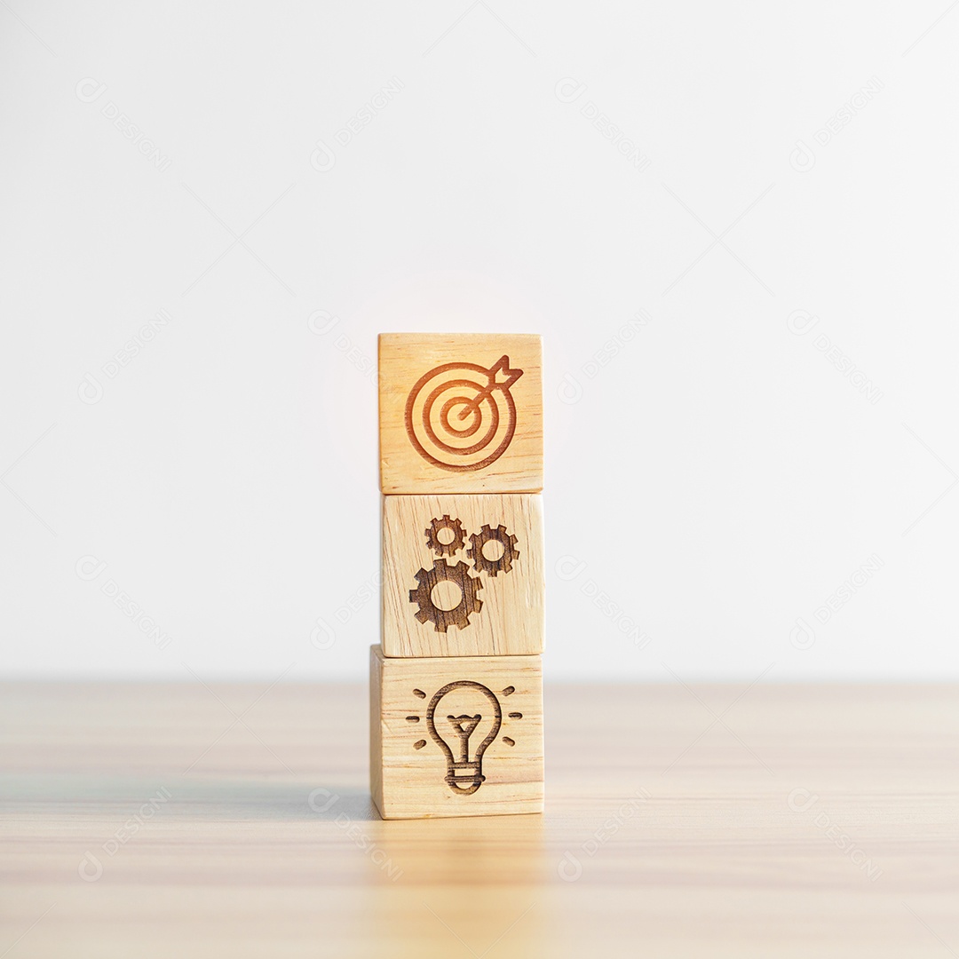 Alvo de dardos acima do bloco de ícone de engrenagem e lâmpada na mesa