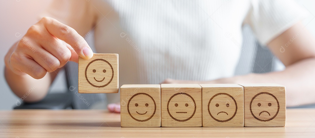 Mão escolhendo rosto sorridente do bloco Emoção para revisão do cliente