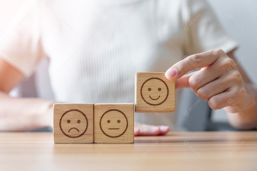 Mão escolhendo rosto sorridente do bloco Emoção para revisão do cliente