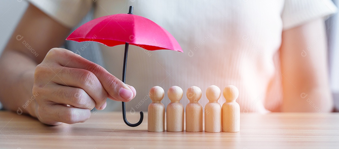 mão segurando o guarda-chuva vermelho e cobrir os homens de madeira da multidão de funcionários. Pessoas, negócios, gestão de recursos humanos, seguro de vida, trabalho em equipe e conceitos de liderança