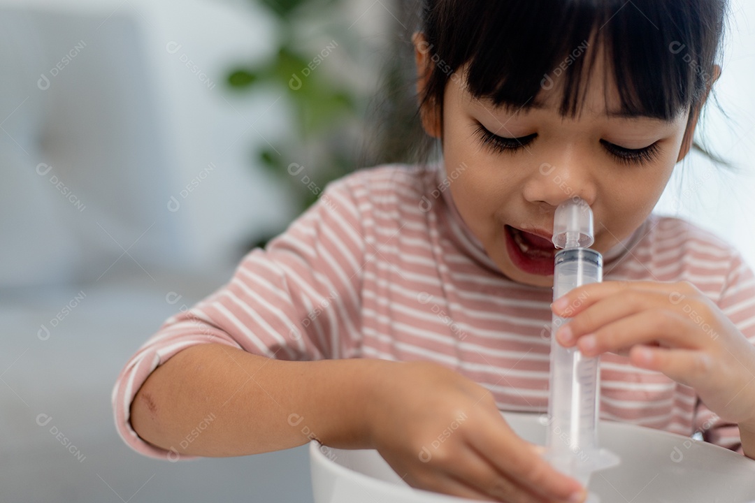Nariz de lavagem nasal salina menina asiática em casa.