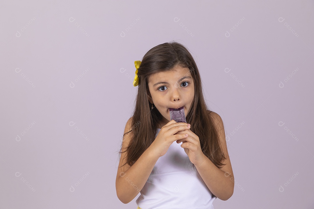 Linda Menina criança garotinha chupando picolé sobre fundo isolado branco