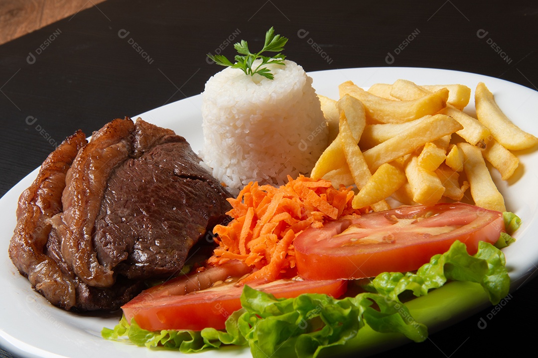 Filé com fritas, servido com arroz e salada de alface, tomate e cenoura.