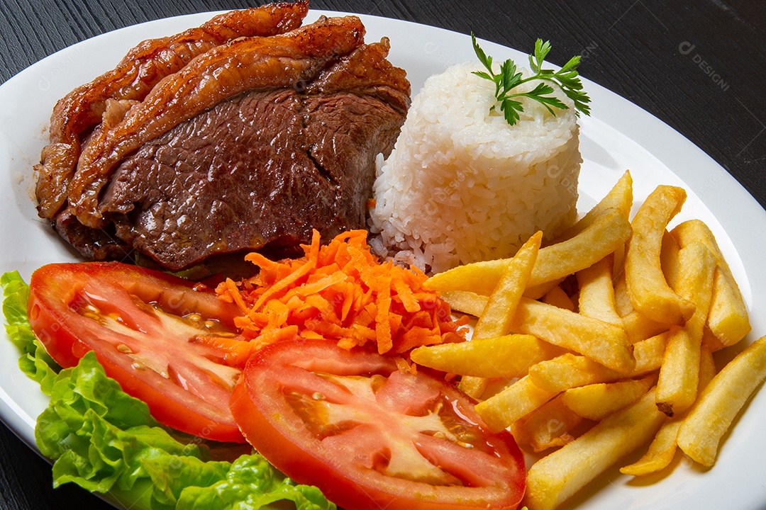 Filé com fritas, servido com arroz e salada de alface, tomate e cenoura.