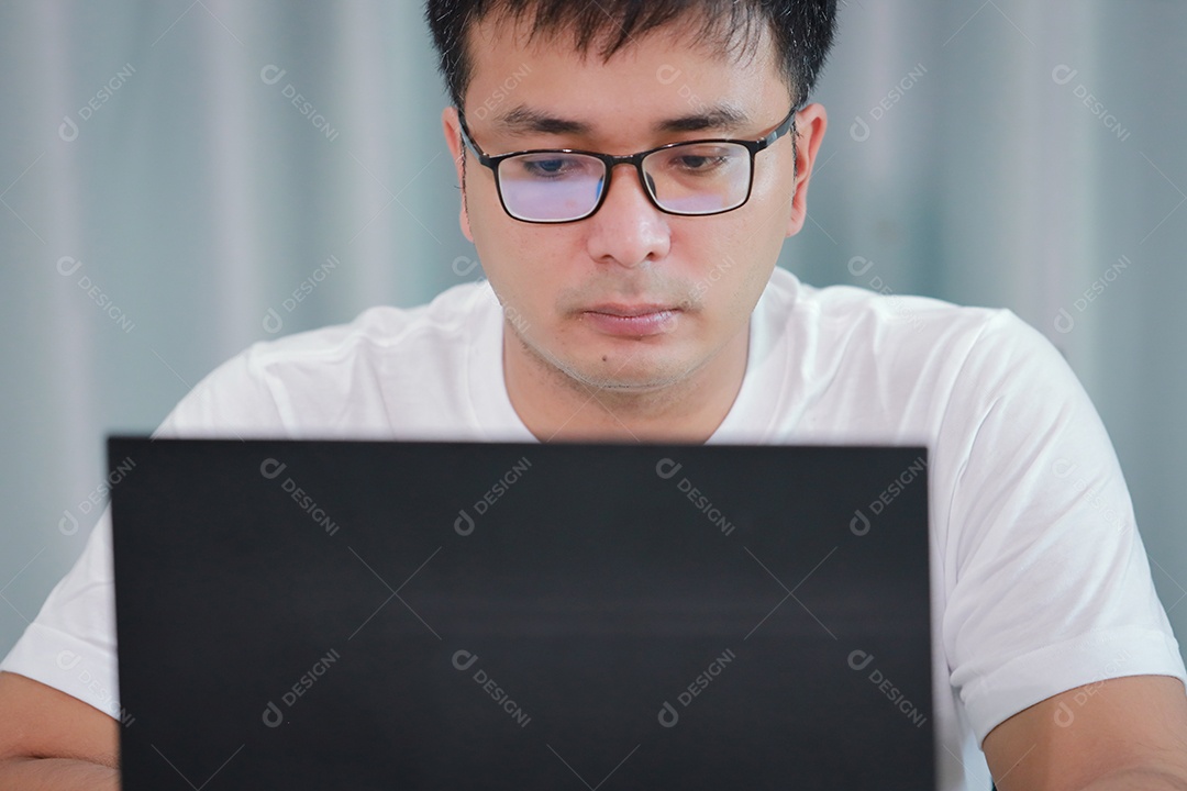 tecnologia, trabalho remoto e conceito de estilo de vida - homem asiático feliz em óculos com computador portátil trabalhando em home office ou compras on-line, trabalho em casa, freelance, aprendizado on-line, estudando.