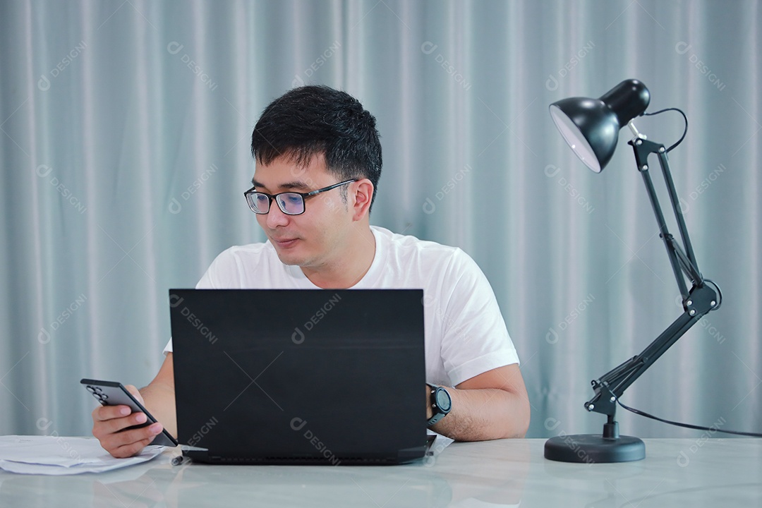 tecnologia, trabalho remoto e conceito de estilo de vida - homem asiático feliz em óculos com computador portátil trabalhando em home office ou compras on-line, trabalho em casa, freelance, aprendizado on-line, estudando.