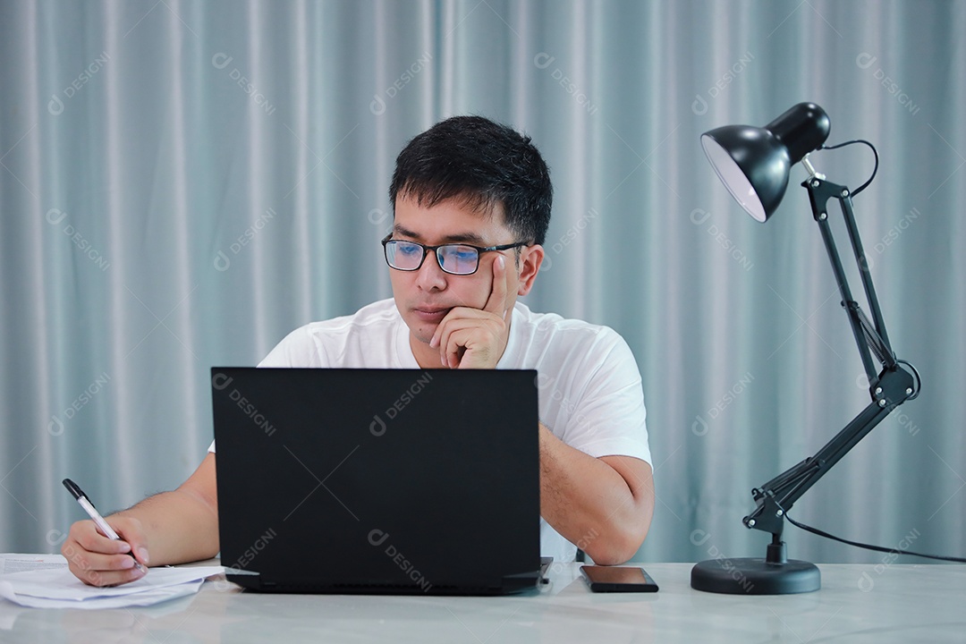 tecnologia, trabalho remoto e conceito de estilo de vida - homem asiático feliz em óculos com computador portátil trabalhando em home office ou compras on-line, trabalho em casa, freelance, aprendizado on-line, estudando.