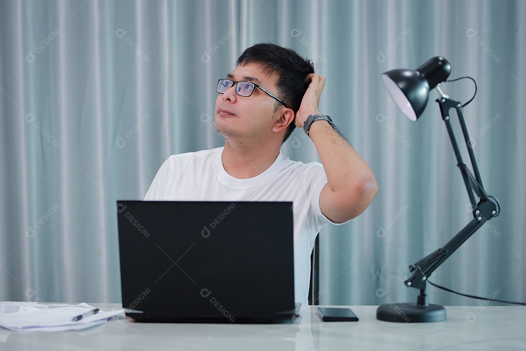 tecnologia, trabalho remoto e conceito de estilo de vida - homem asiático feliz em óculos com computador portátil trabalhando em home office ou compras on-line, trabalho em casa, freelance, aprendizado on-line, estudando.