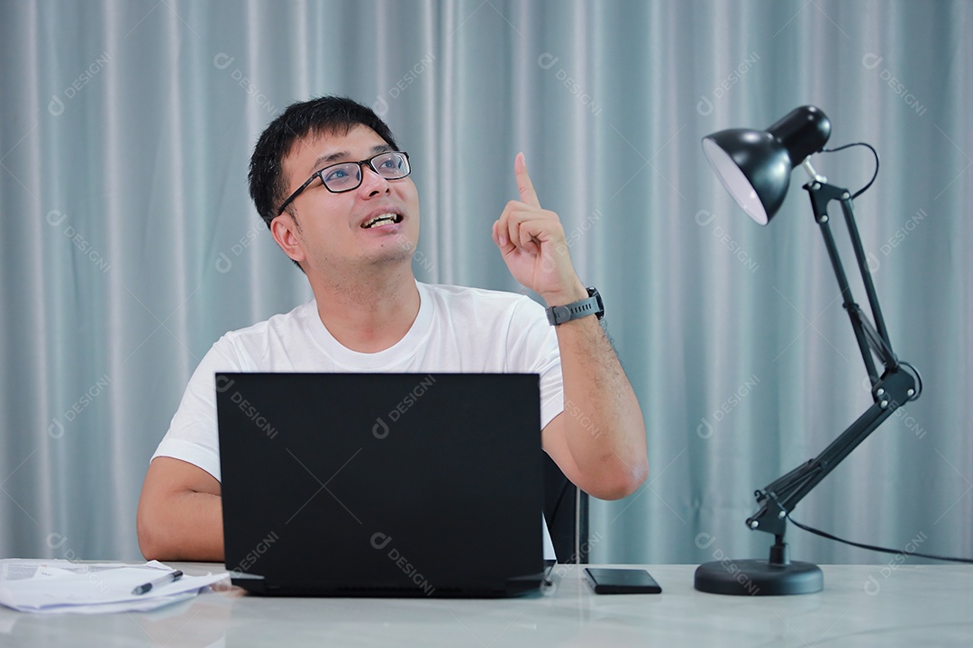 tecnologia, trabalho remoto e conceito de estilo de vida - homem asiático feliz em óculos com computador portátil trabalhando em home office ou compras on-line, trabalho em casa, freelance, aprendizado on-line, estudando.