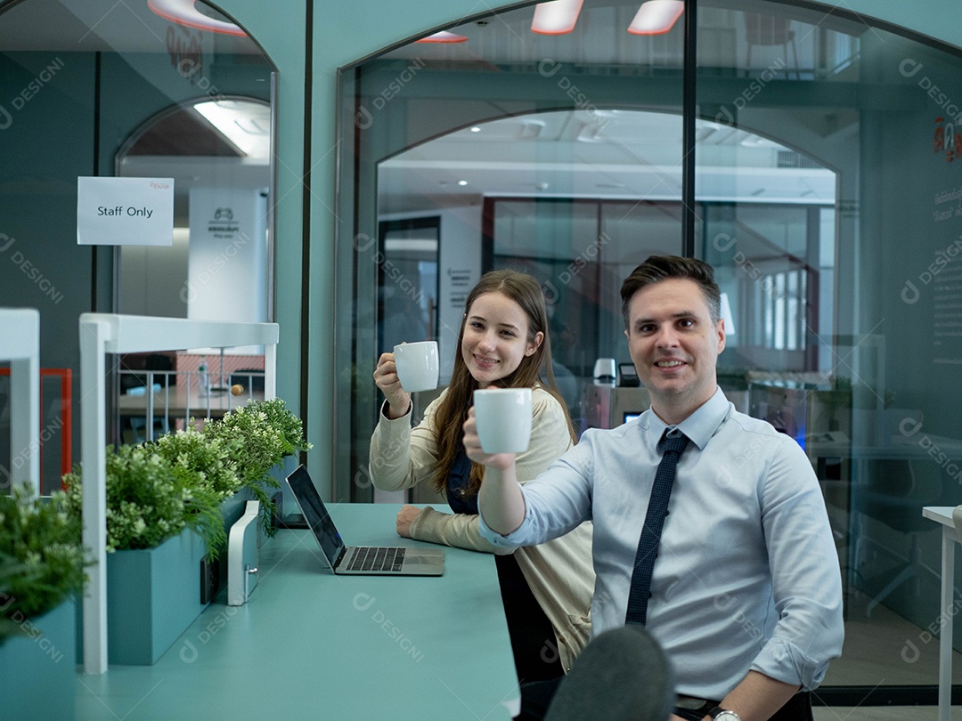 Empresários sentado feliz segurando xícaras de café no interior do escritório