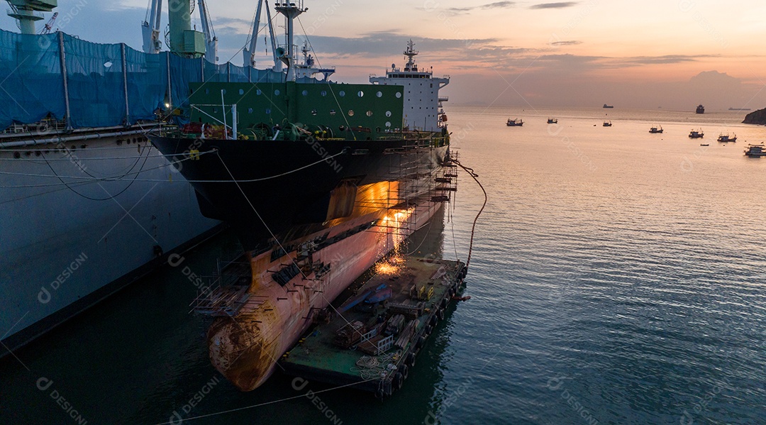 Navio porta-contentores de carga no serviço de manutenção do conceito de doca seca trabalhando no mar. Conceito de navio de carga de seguro e manutenção. corte de metal de navio com gás