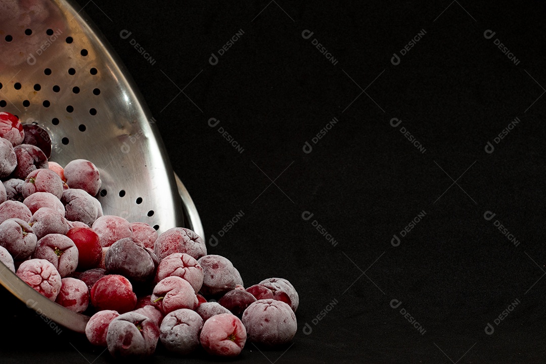 Tigela cheia de acerolas congeladas e frescas