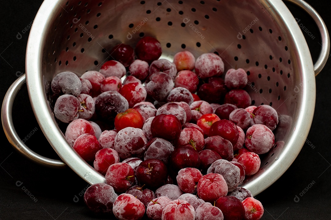 Tigela cheia de acerolas congeladas e frescas