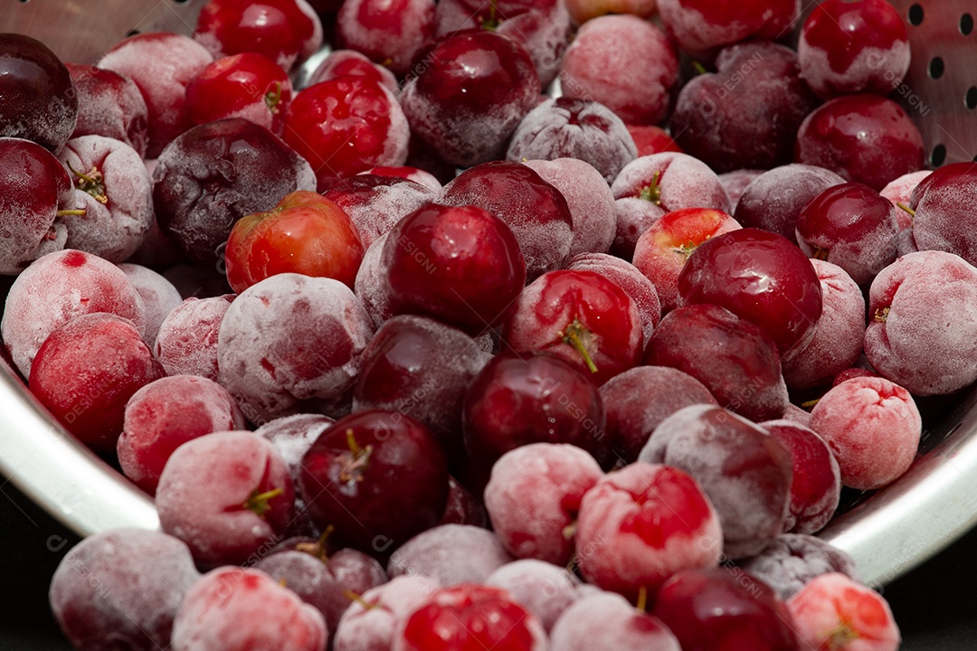 Tigela cheia de acerolas congeladas e frescas