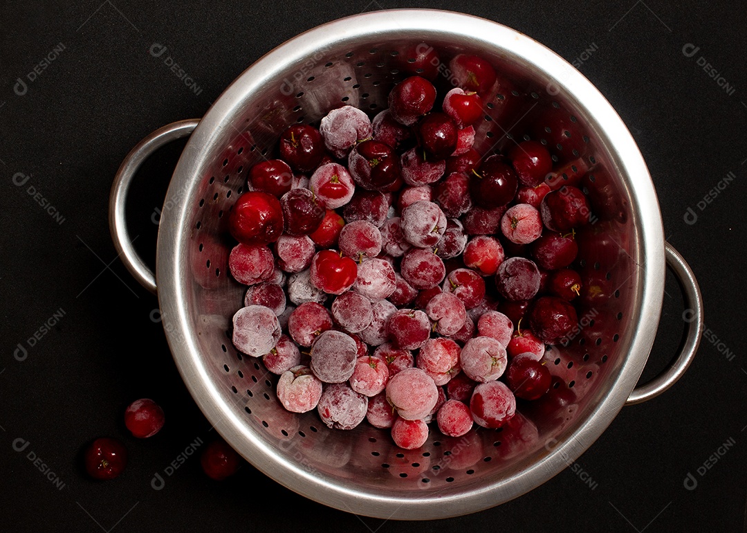 Tigela cheia de acerolas congeladas e frescas