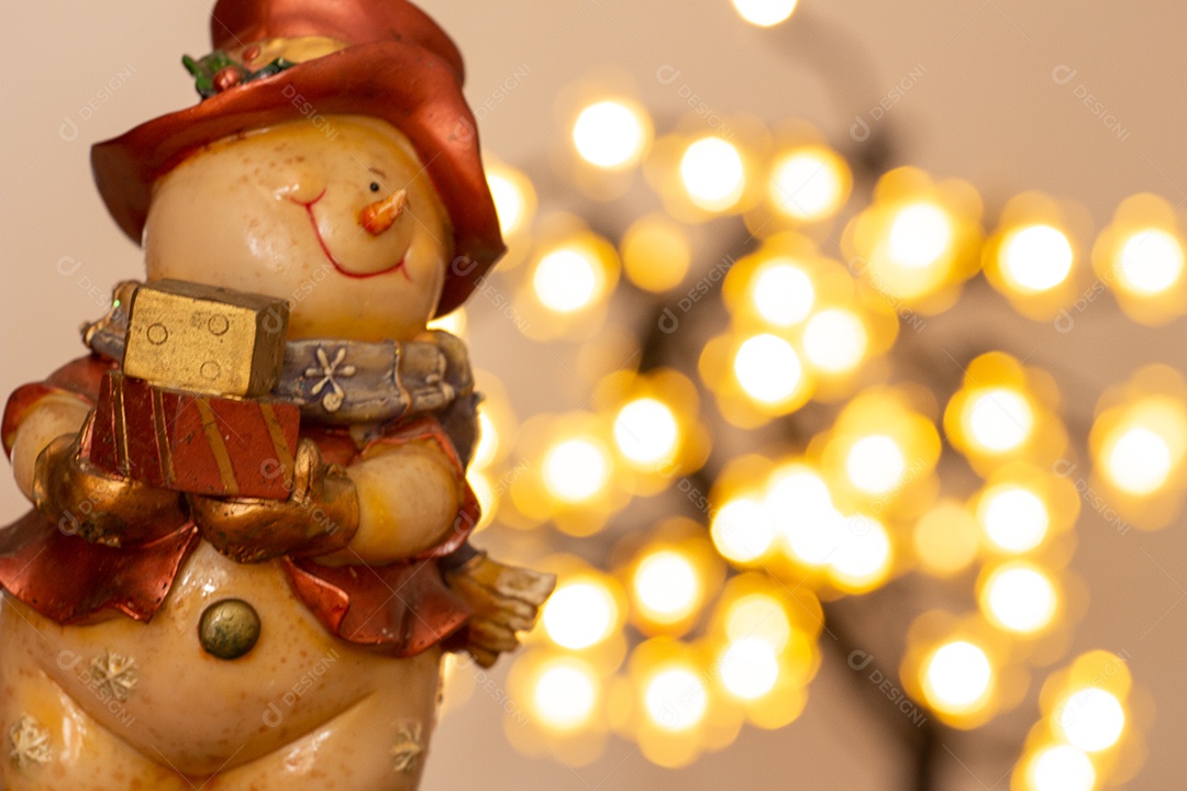 Atmosfera de natal com boneco de neve, duas velas e bokeh