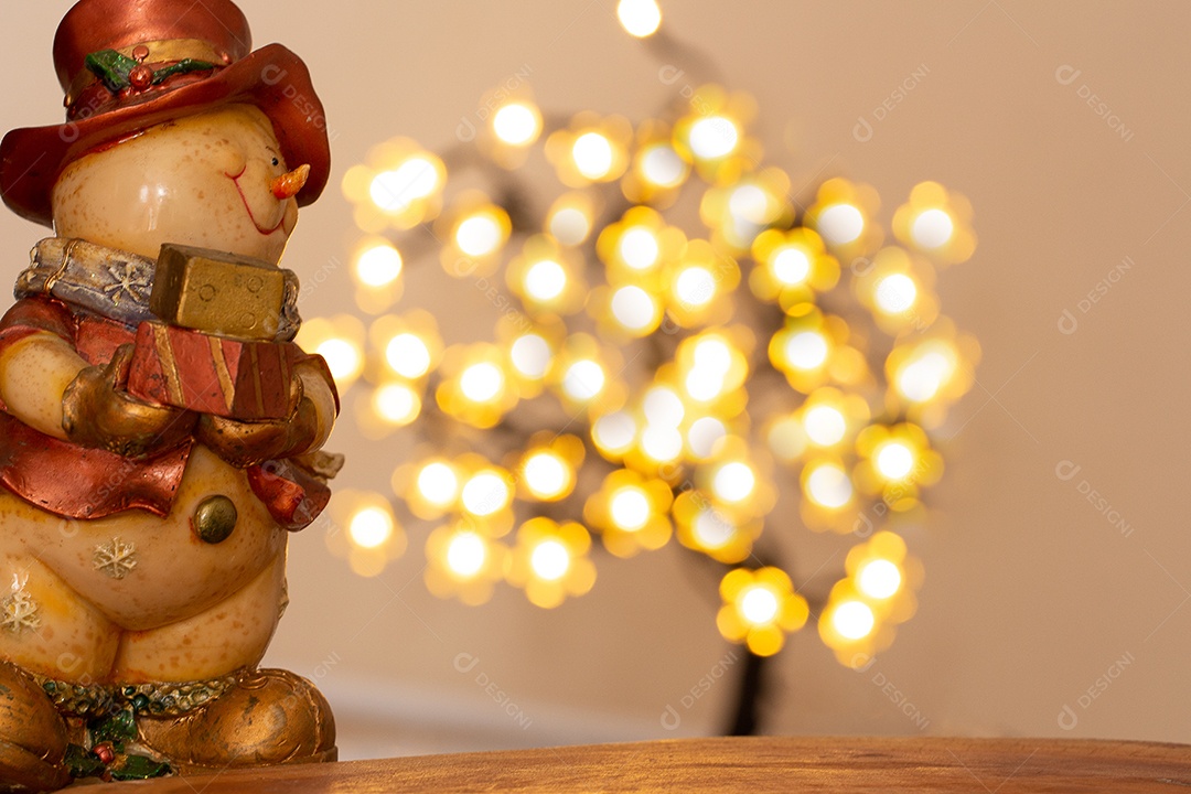 Atmosfera de natal com boneco de neve, duas velas e bokeh