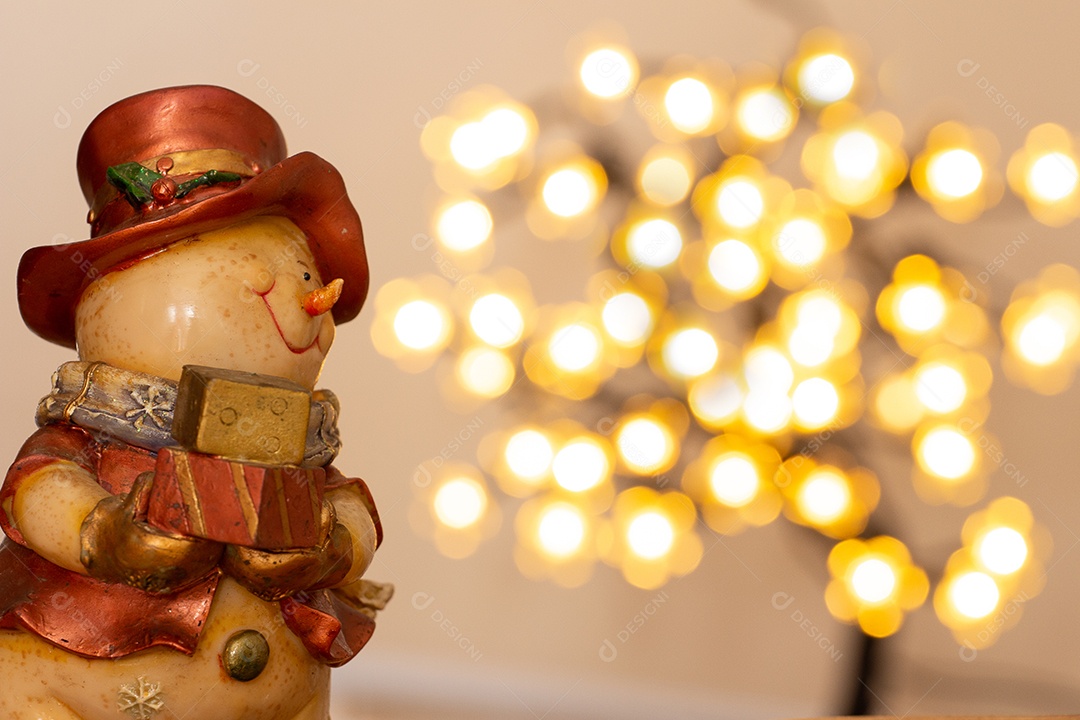 Atmosfera de natal com boneco de neve, duas velas e bokeh