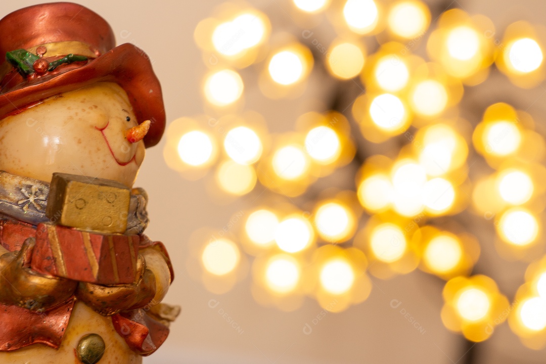 Atmosfera de natal com boneco de neve, duas velas e bokeh