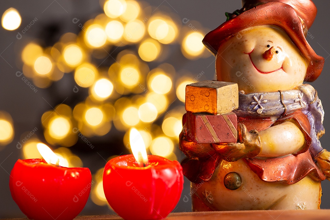 Atmosfera de natal com boneco de neve, duas velas e bokeh