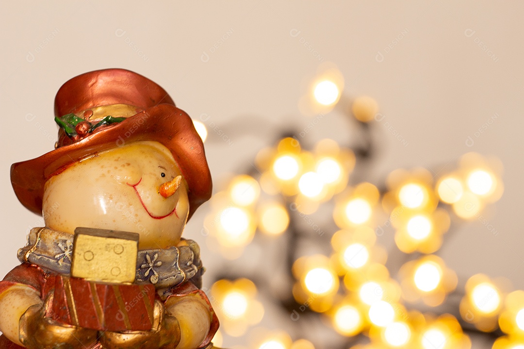 Atmosfera de natal com boneco de neve, duas velas e bokeh