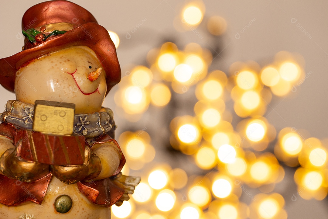 Atmosfera de natal com boneco de neve, duas velas e bokeh