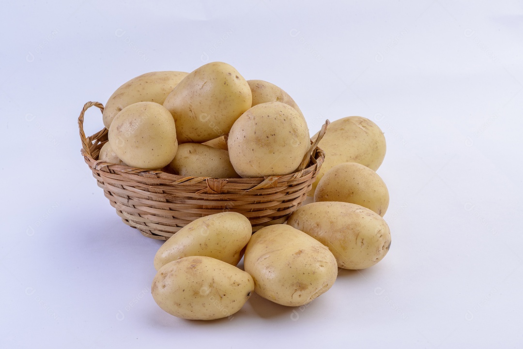 Batatas dentro da cesta de palha isolada no fundo branco.