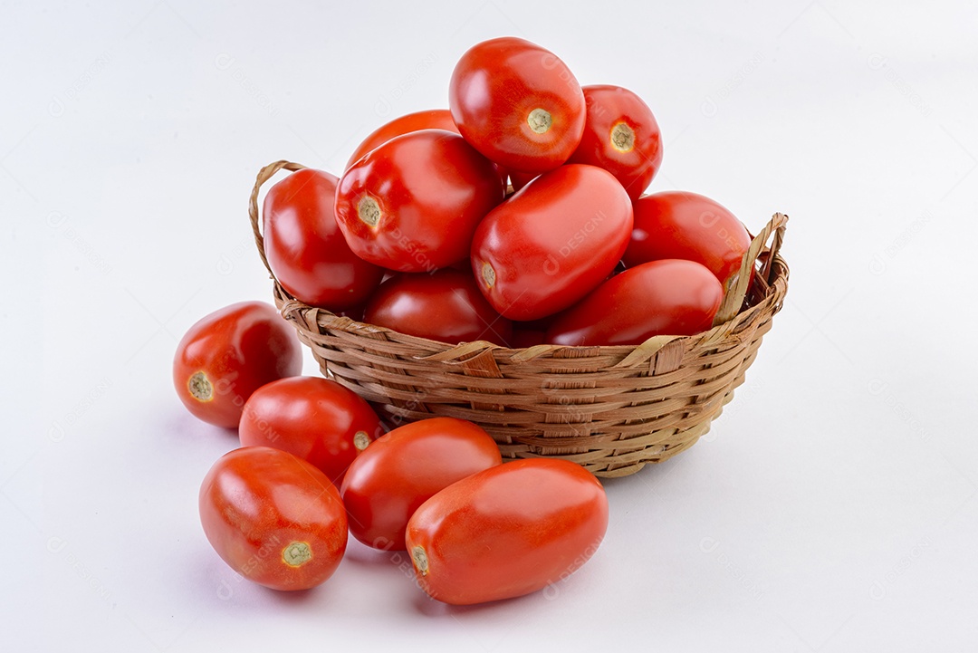 Tomates dentro da cesta de palha isolada no fundo branco.