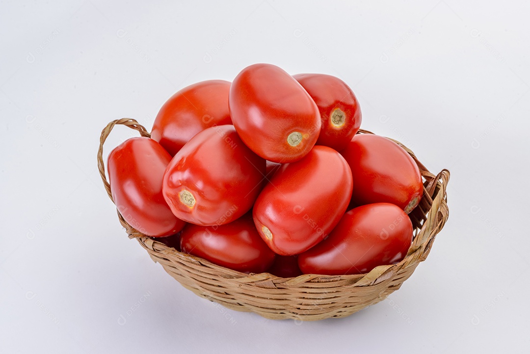 Tomates dentro da cesta de palha isolada no fundo branco.