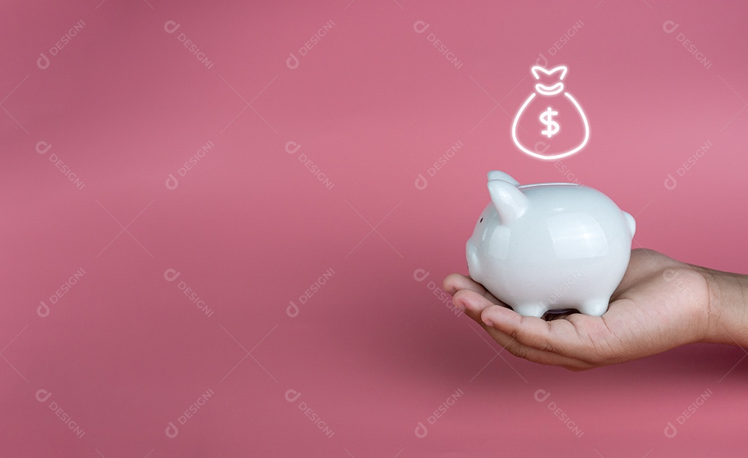 Mão segurando um cofrinho branco sobre um fundo rosa.